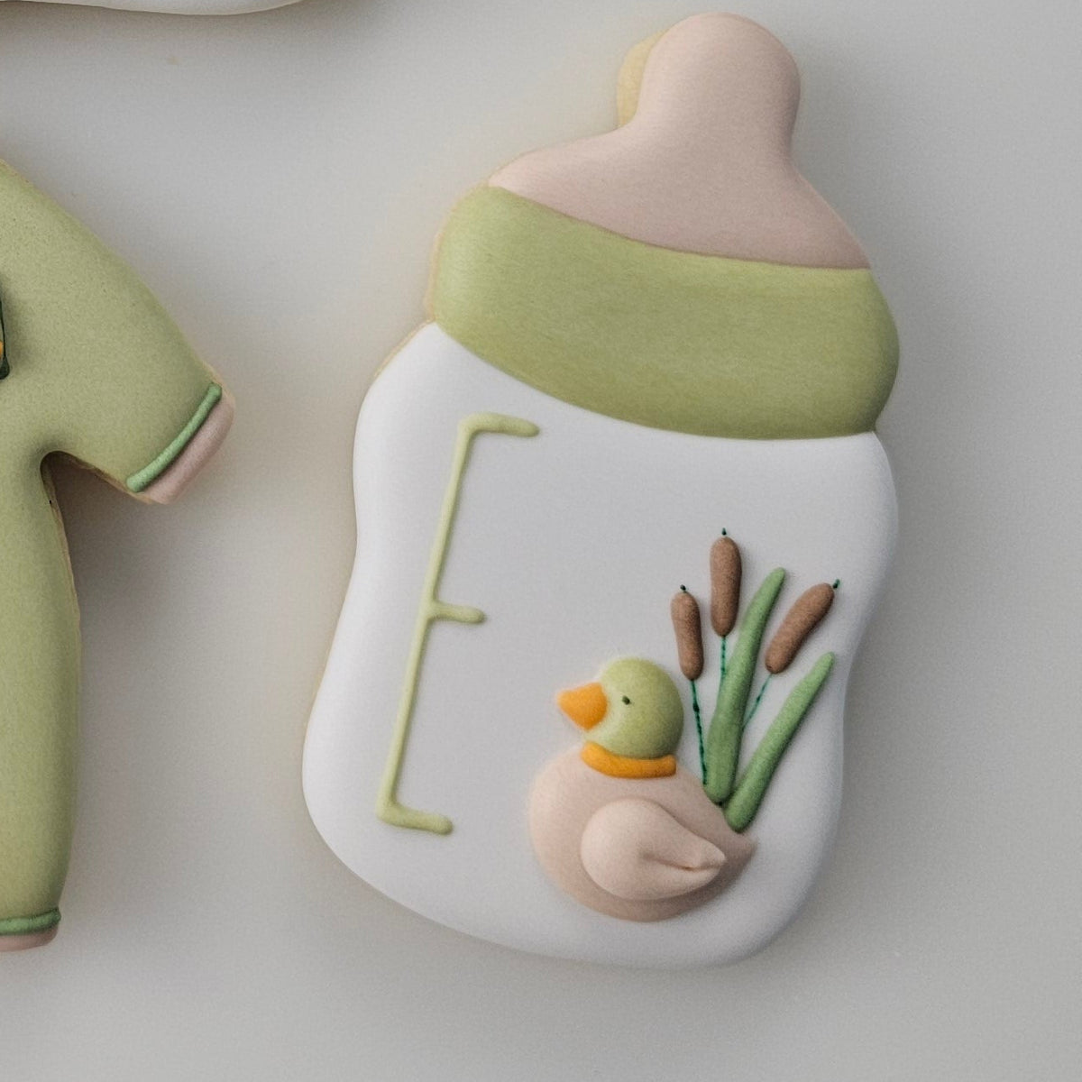 A little Hunter is on the way decorated baby shower cookies set featuring duck, bib, overalls, and bootie royal icing transfers