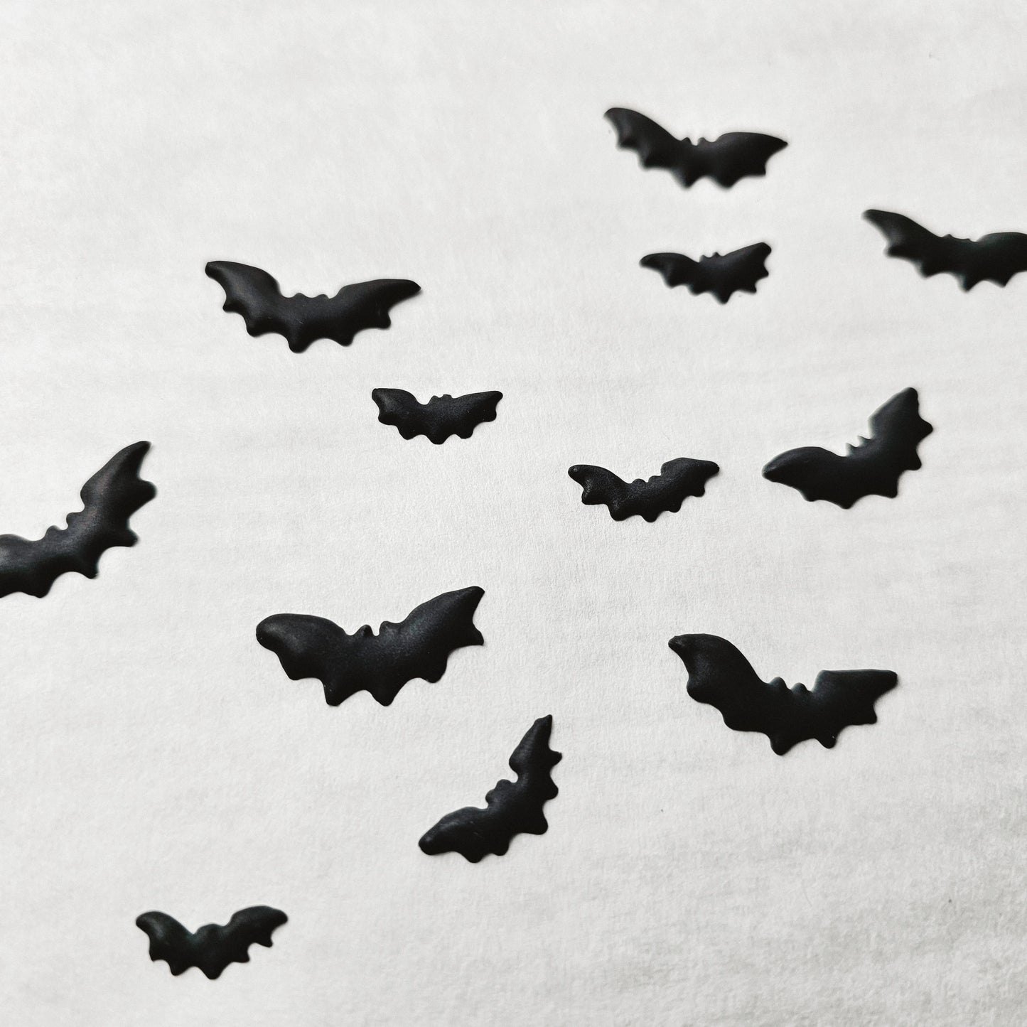 Black bat-shaped royal icing transfers on a white background