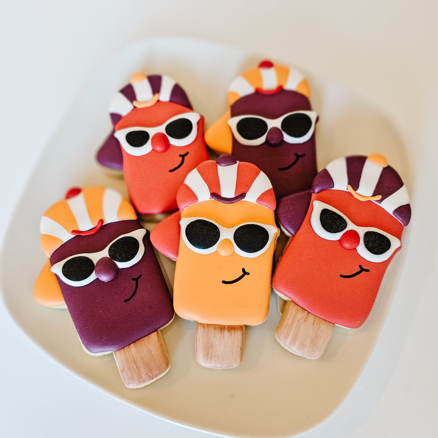 Cool popsicle sugar cookies on a white plate