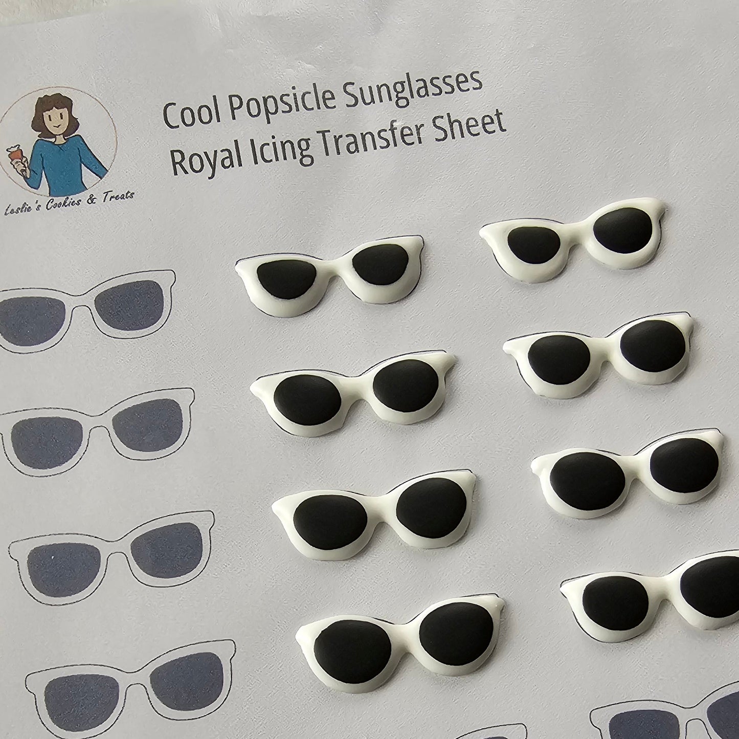 Sheet of sunglasses-shaped royal icing transfers on a white background