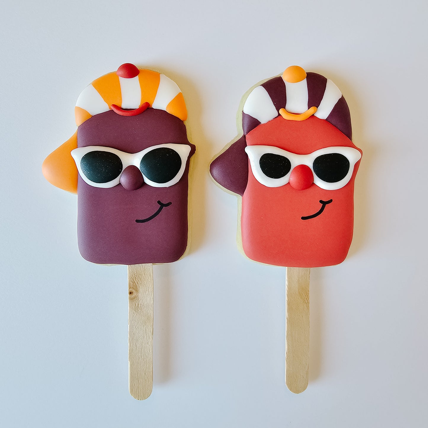 Popsicle sugar cookies wearing hats and sunglasses