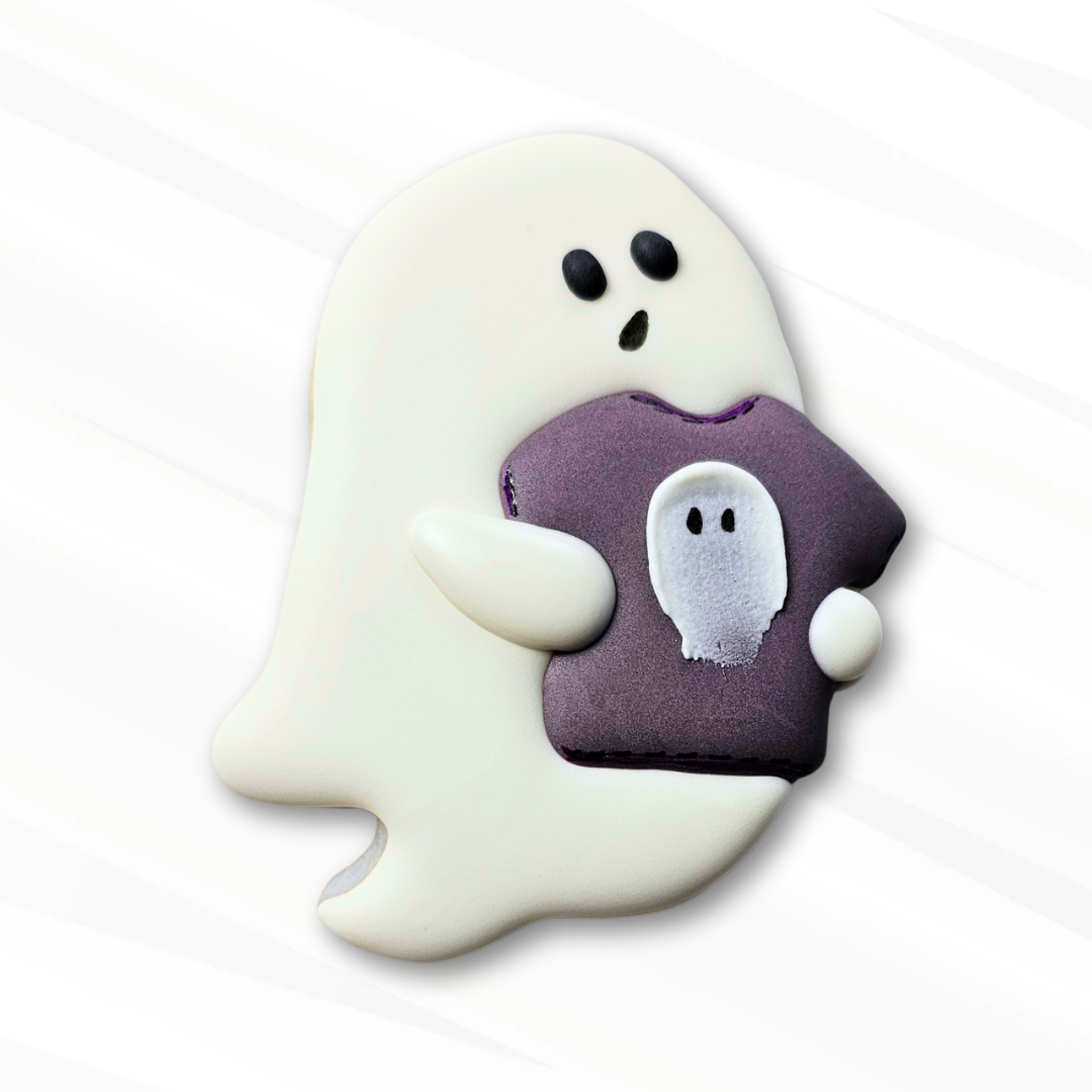 Sugar Cookie of a Ghost holding a purple shirt featuring a smaller ghost design on a white background