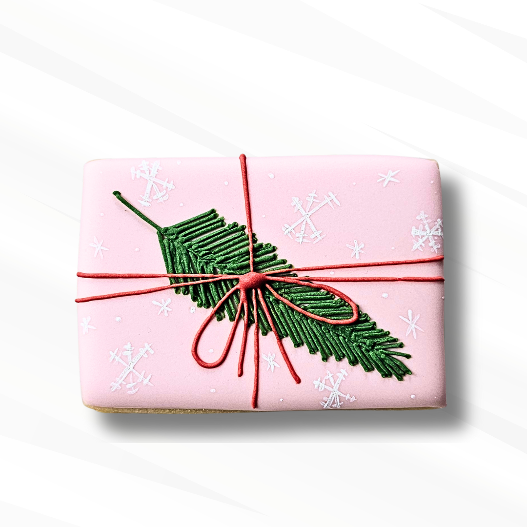 a sugar cookie decorated to look like a Christmas gift on a white background