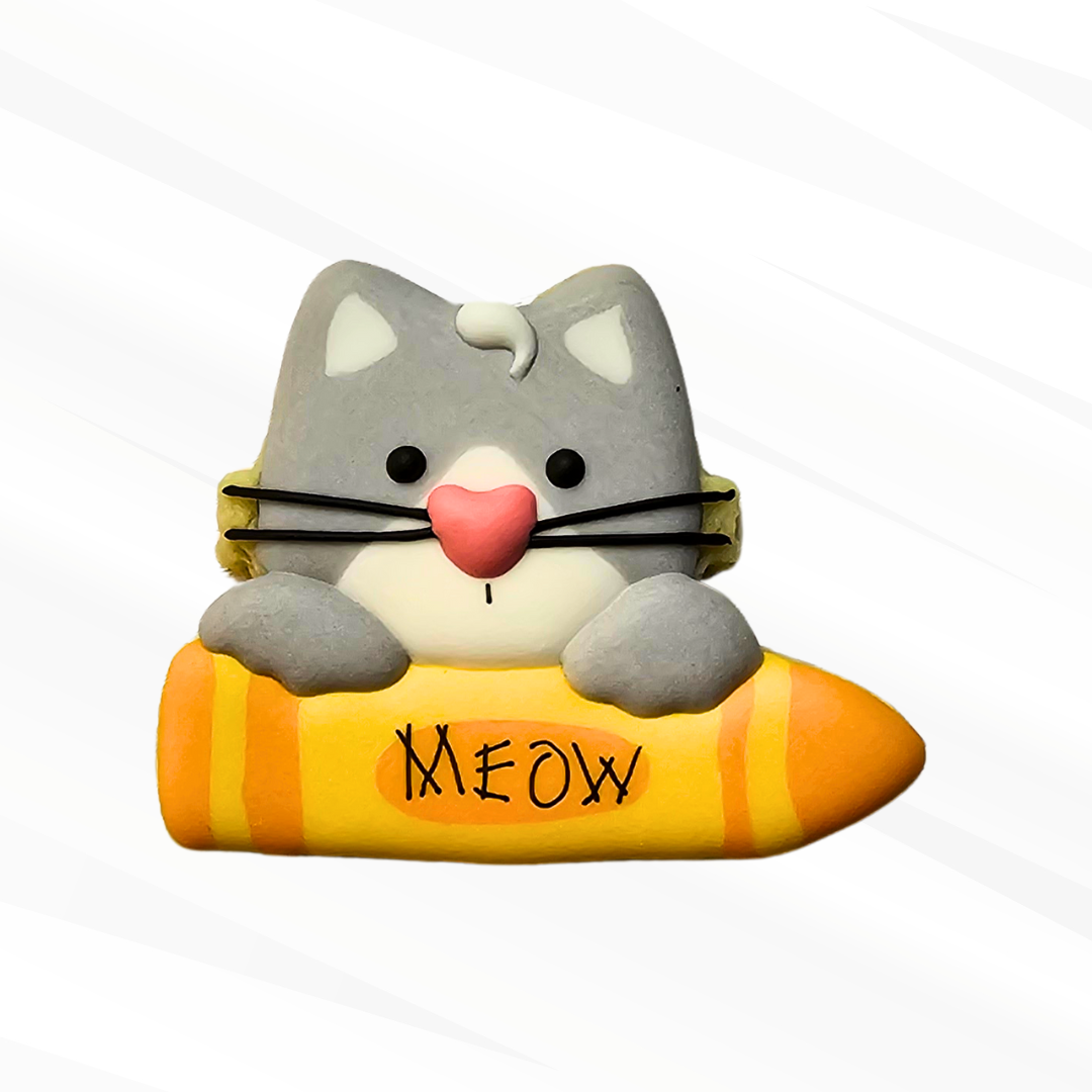 Gray Cat holding an orange crayon sugar cookie