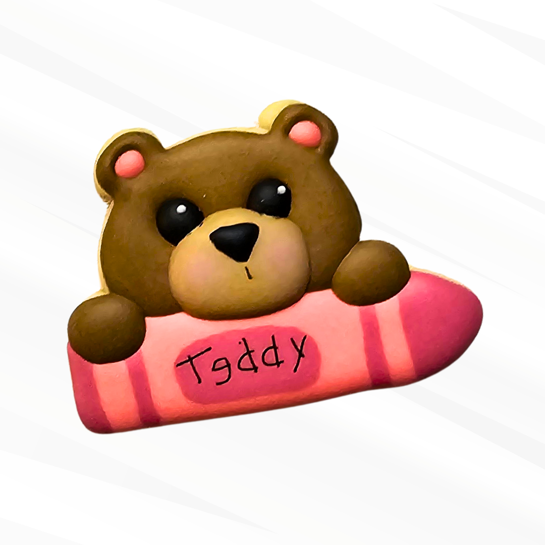 Teddy Bear Sugar Cookie holding a pink crayon