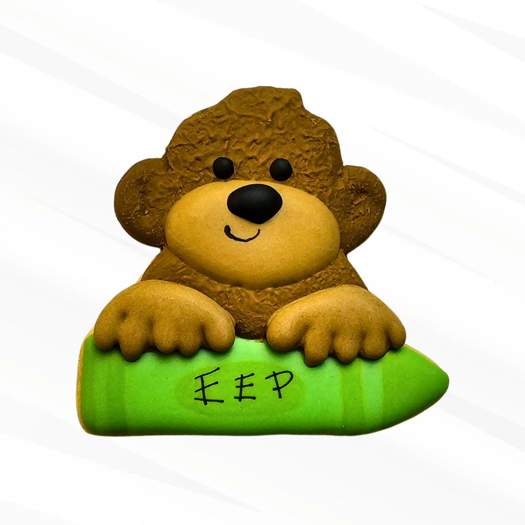 Fuzzy monkey holding a green crayon sugar cookie
