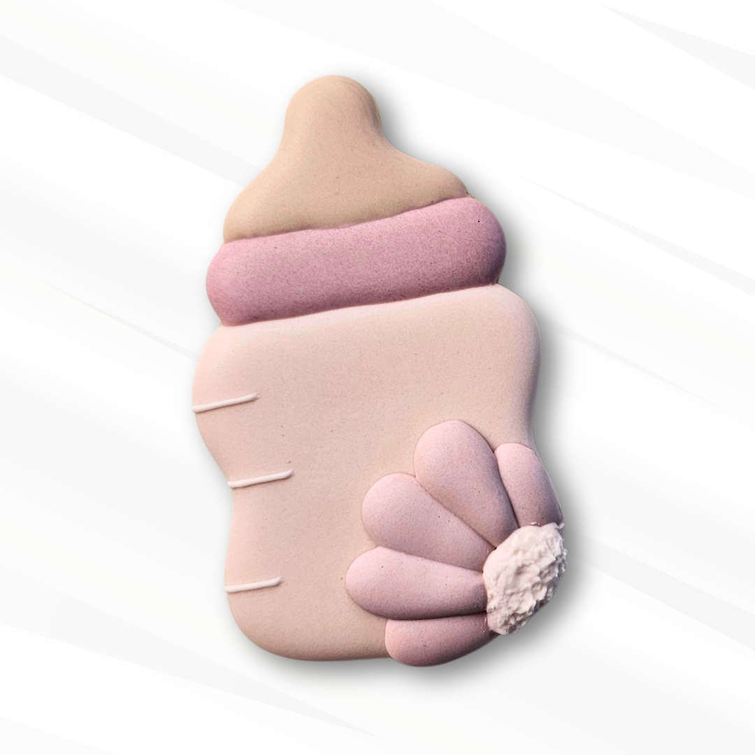 Pink baby bottle sugar cookie with a flower on a white background