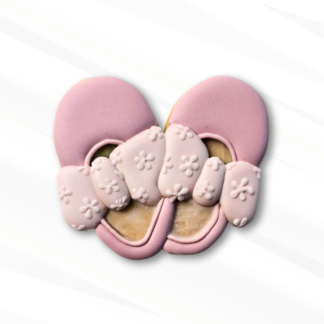 Pink baby shoes with a flower design on the bows on a white background