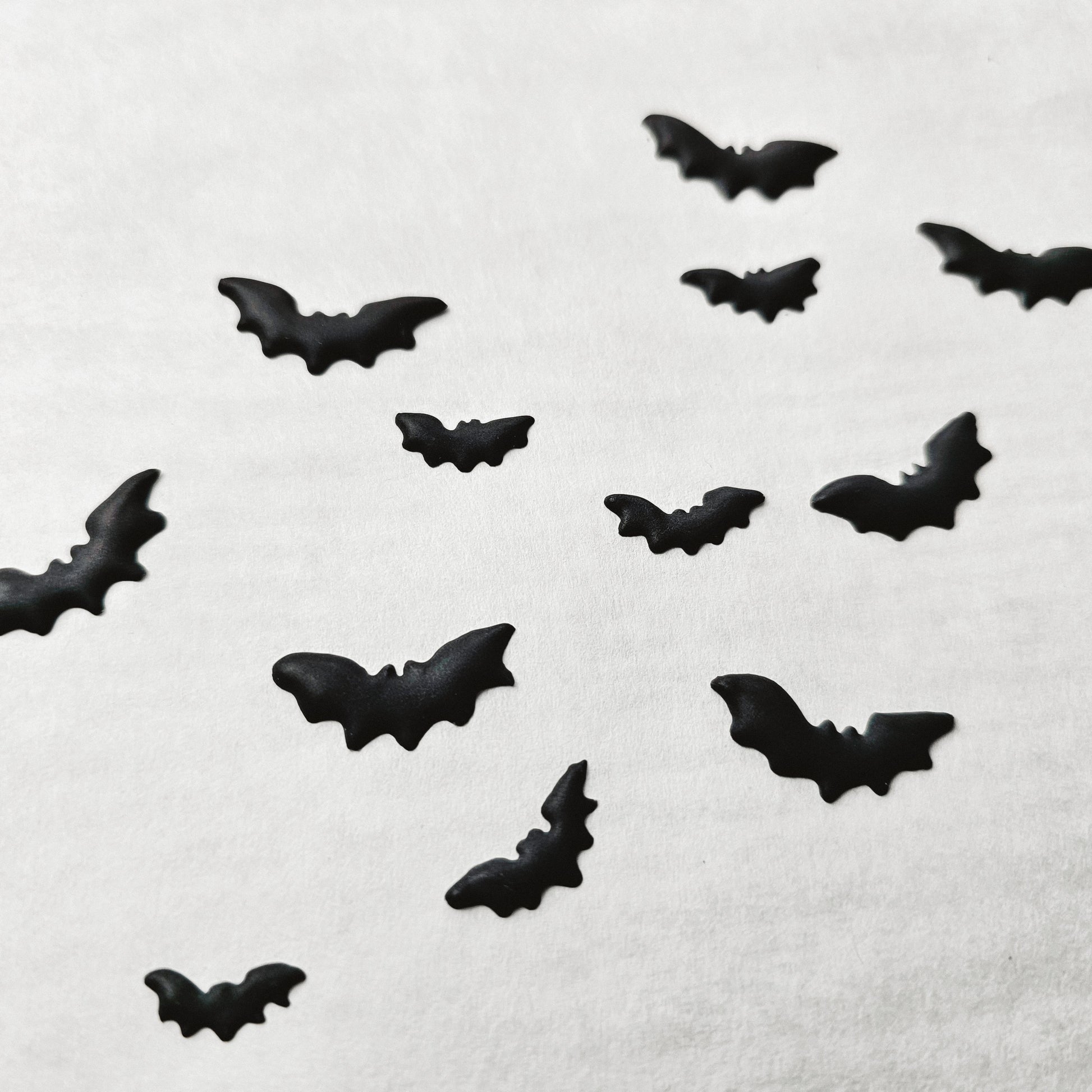 Black bat-shaped royal icing transfers on a white background