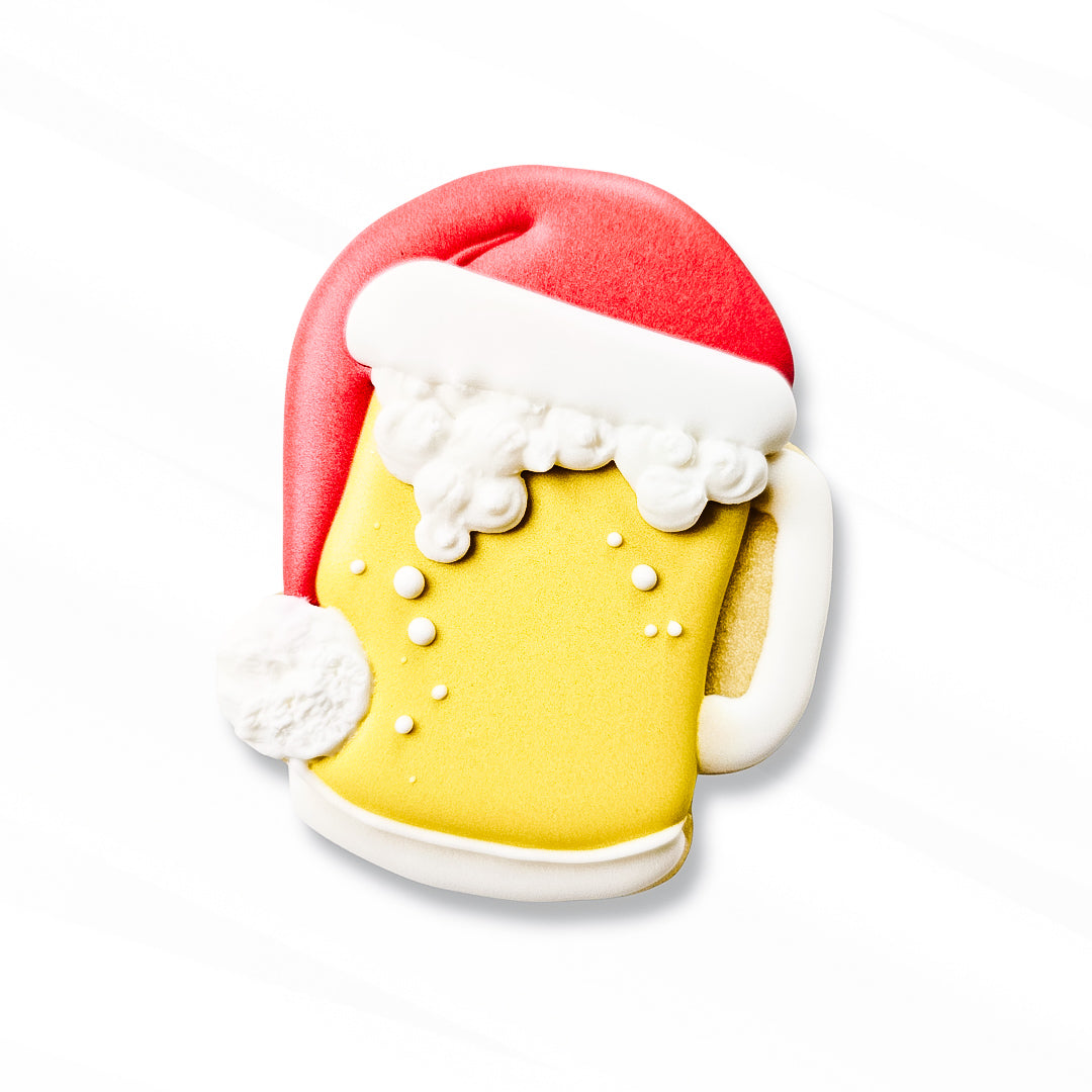 Decorative sugar cookie shaped like a beer mug with a Santa hat on a white background