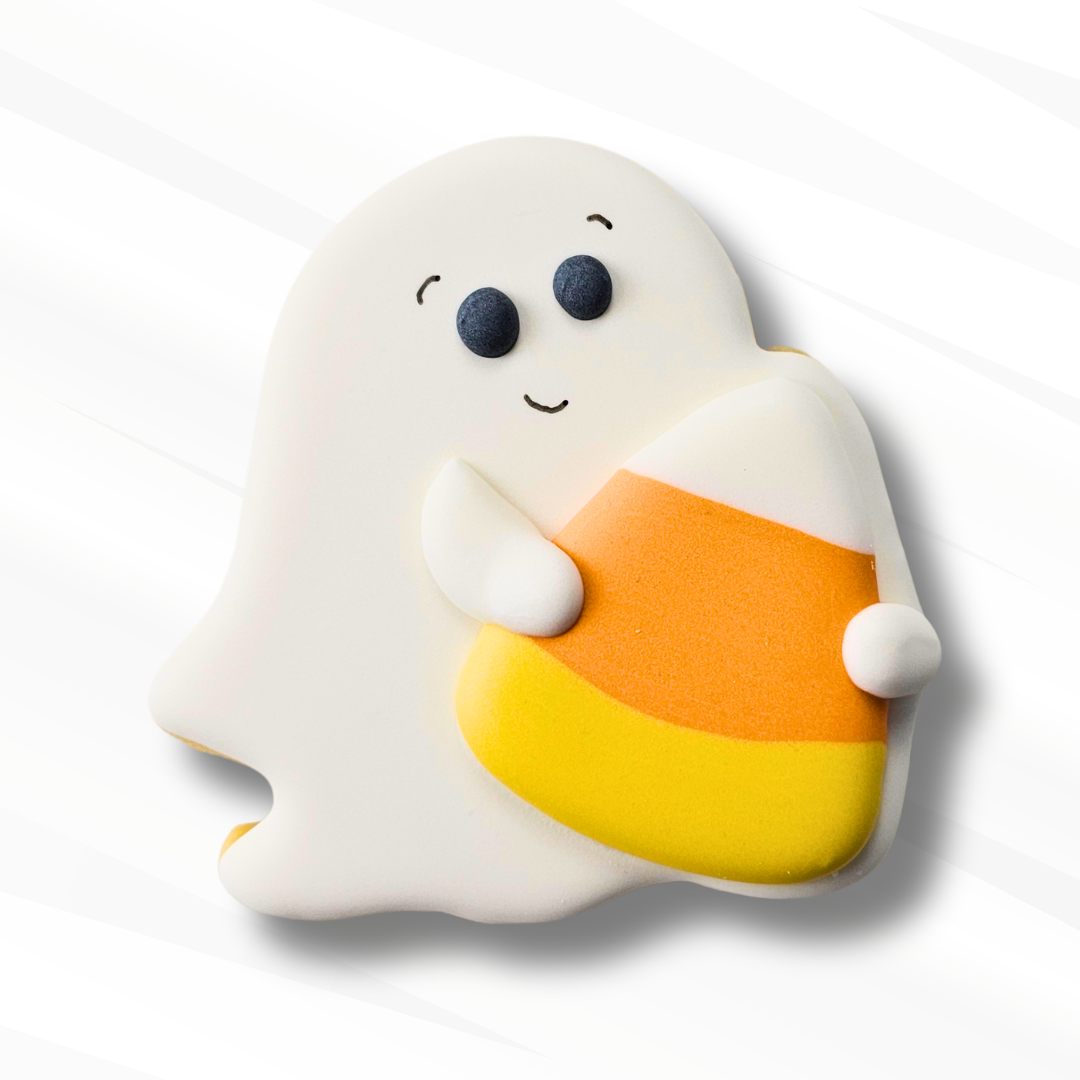 A cute ghost-shaped sugar cookie decorated with white icing and holding a candy corn royal icing transfer in orange and yellow, set against a clean white background with soft diagonal shadows.