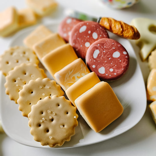 a plate of cookies that look like crackers, cheese and salami
