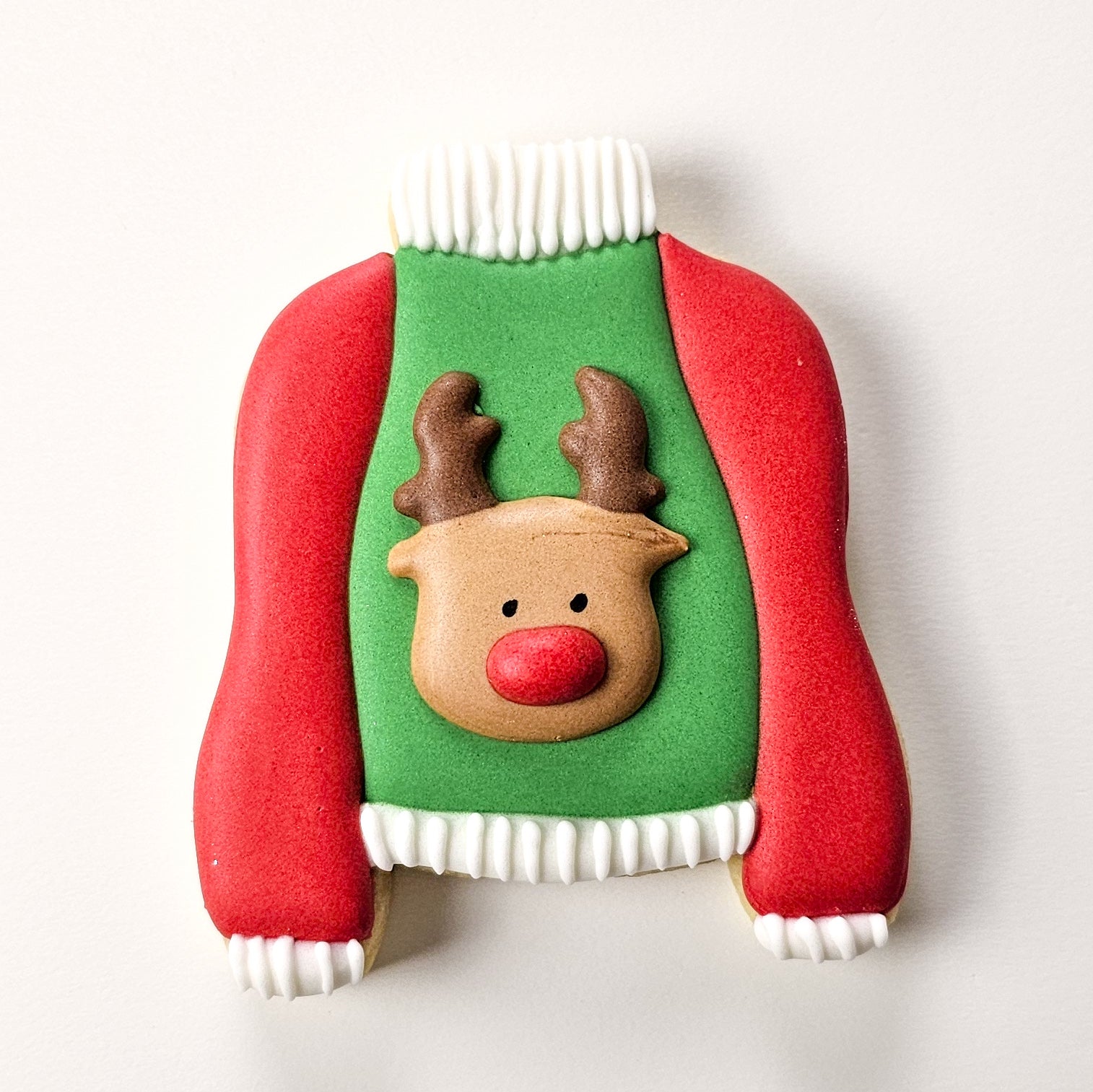 Ugly sweater sugar cookie with a reindeer royal icing transfer