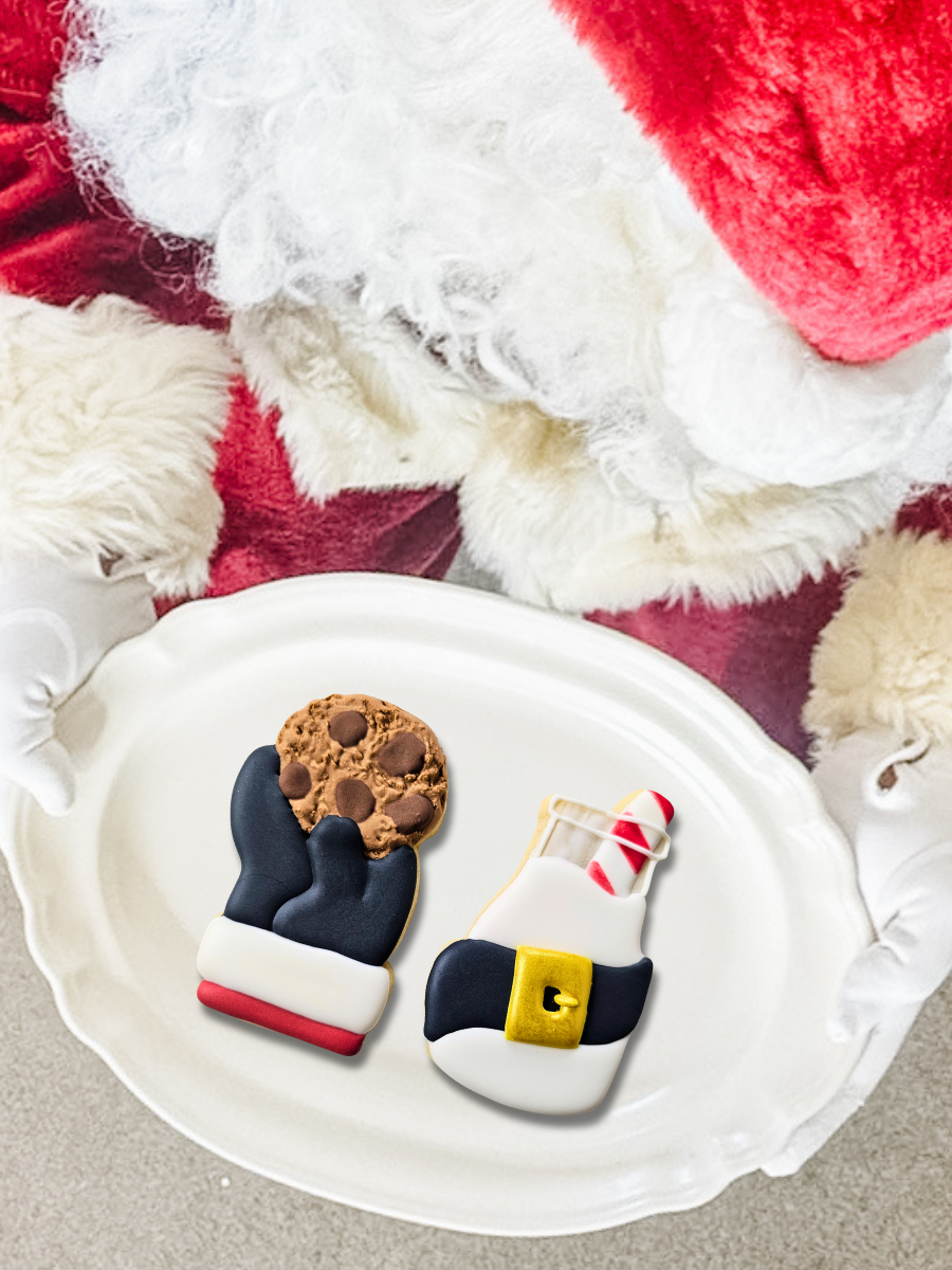Santa holding a plate with 2 Christmas themed sugar cookies