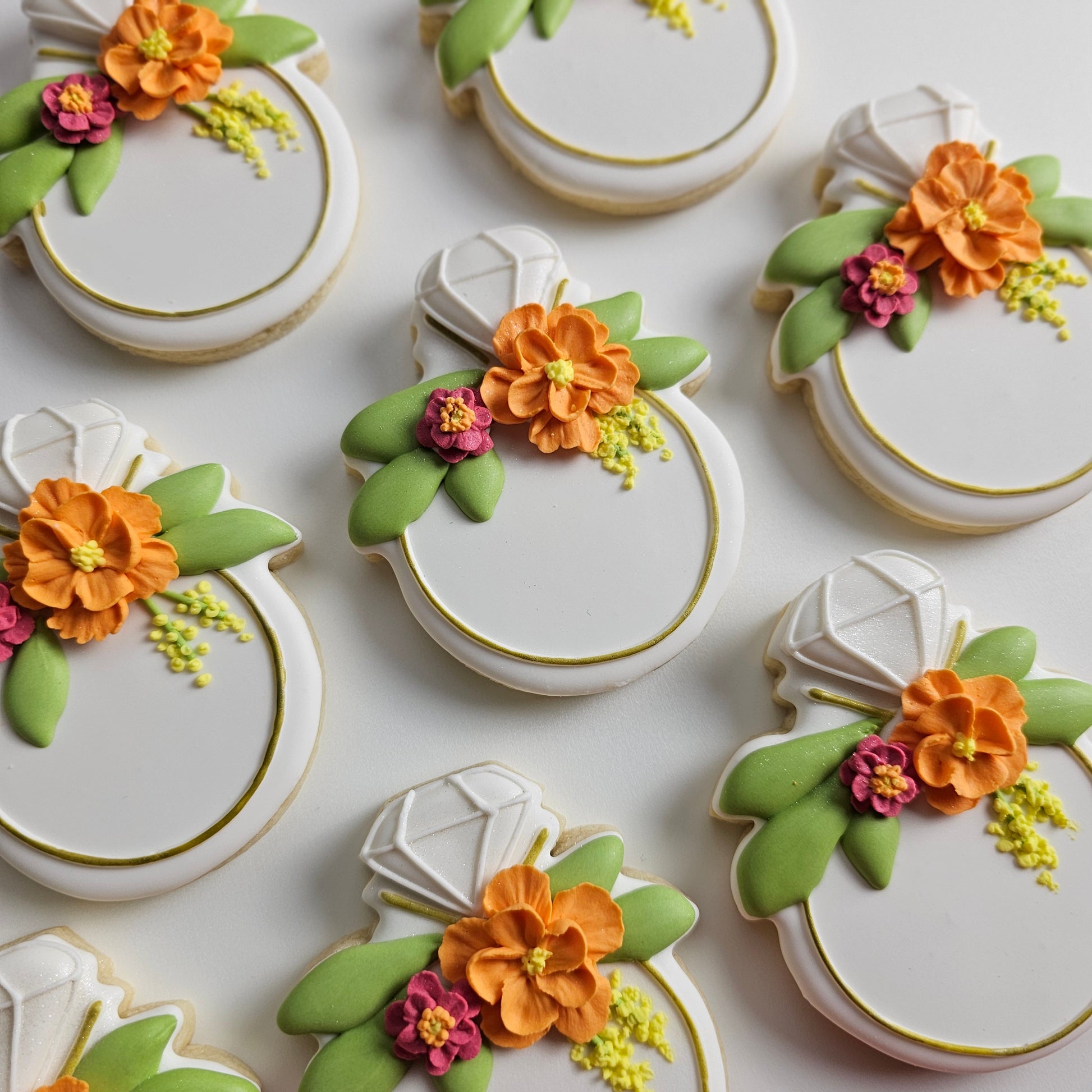 Decorative diamond ring cookies with floral designs on a white background