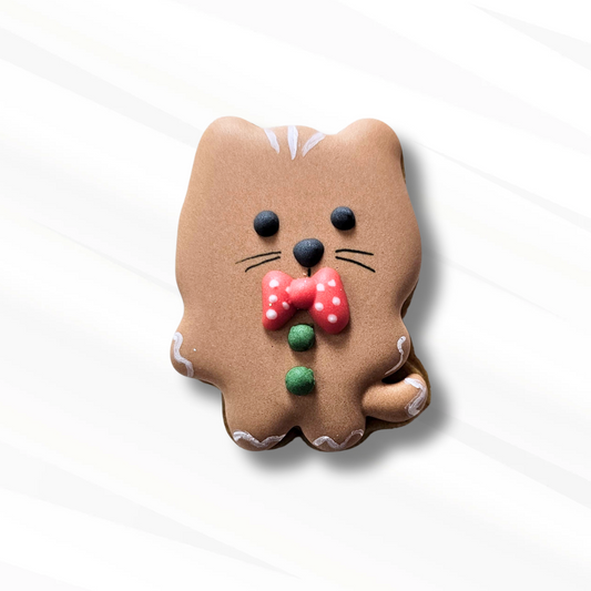 Cat-shaped gingerbread cookie with a bow tie on a white background
