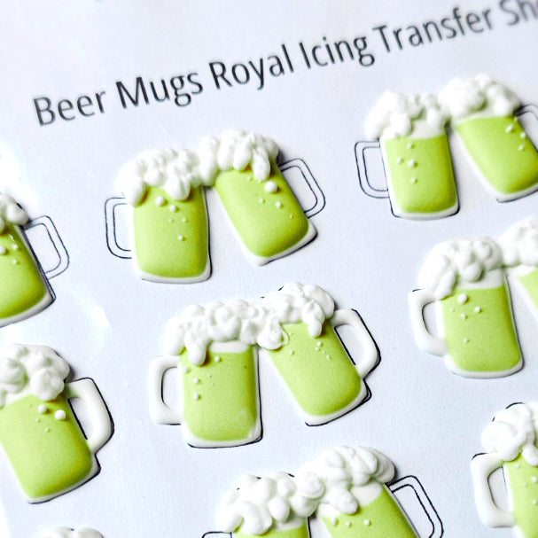 Green beer mug royal icing transfers on a white sheet with text.