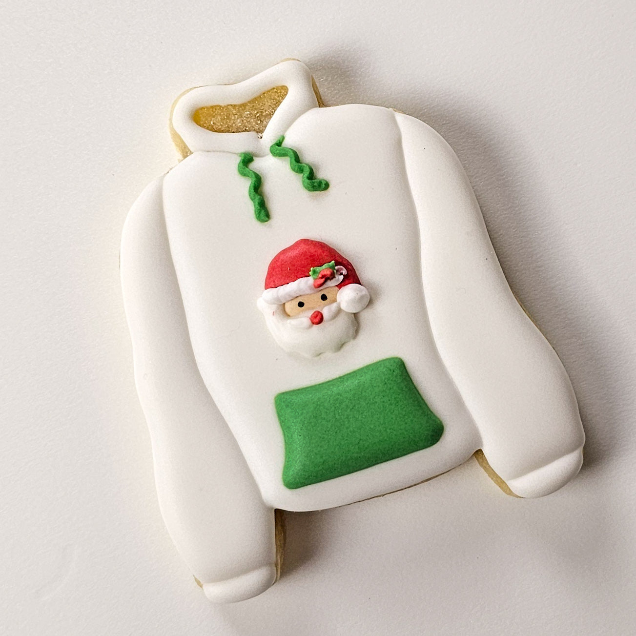 Christmas hoodie sugar cookie with a Santa royal icing transfer