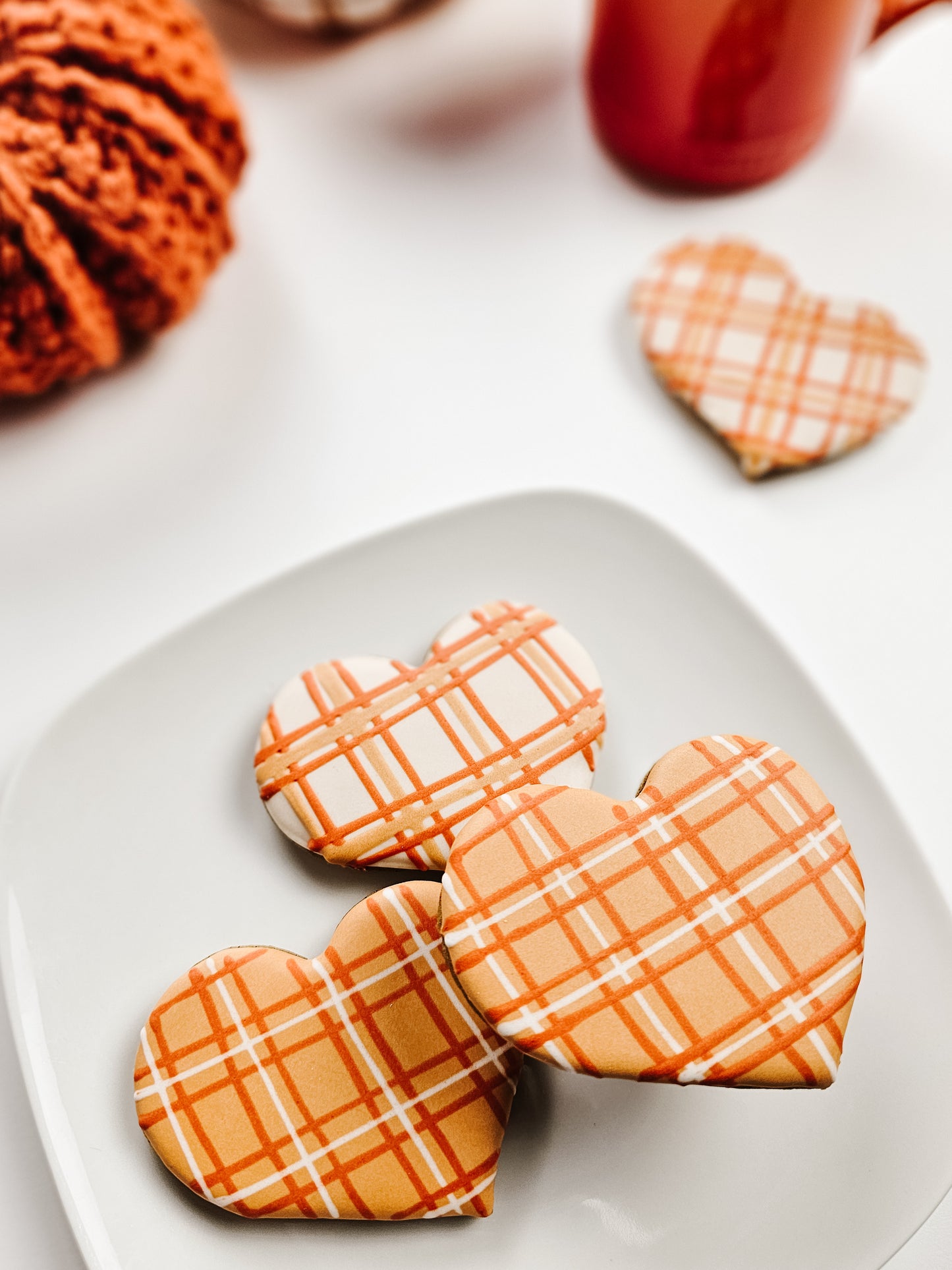 Heart-shaped cookies with plaid design on a white plate