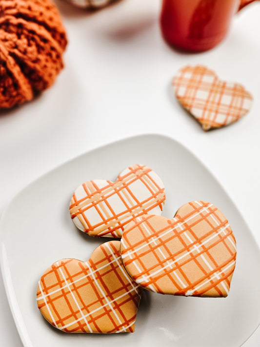 Heart-shaped cookies with plaid design on a white plate