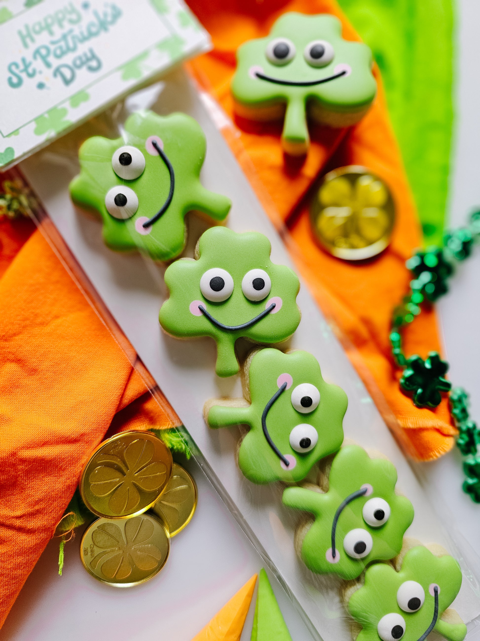 Green clover-shaped cookies with googly eyes for St. Patrick's Day decorations.