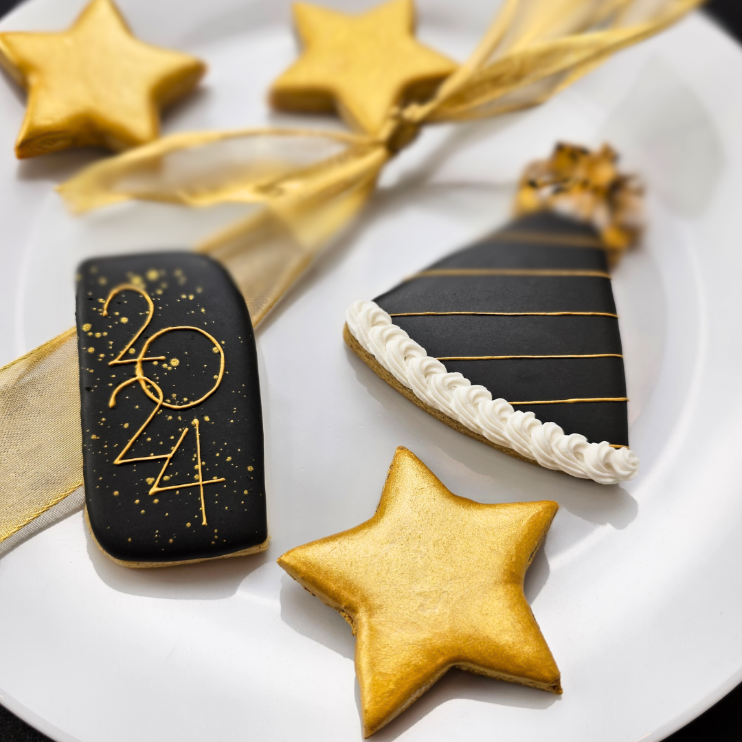 New Year's sugar cookies featuring a gold Star cookie, a party hat cookie, and a rectangular cookie that says 2024