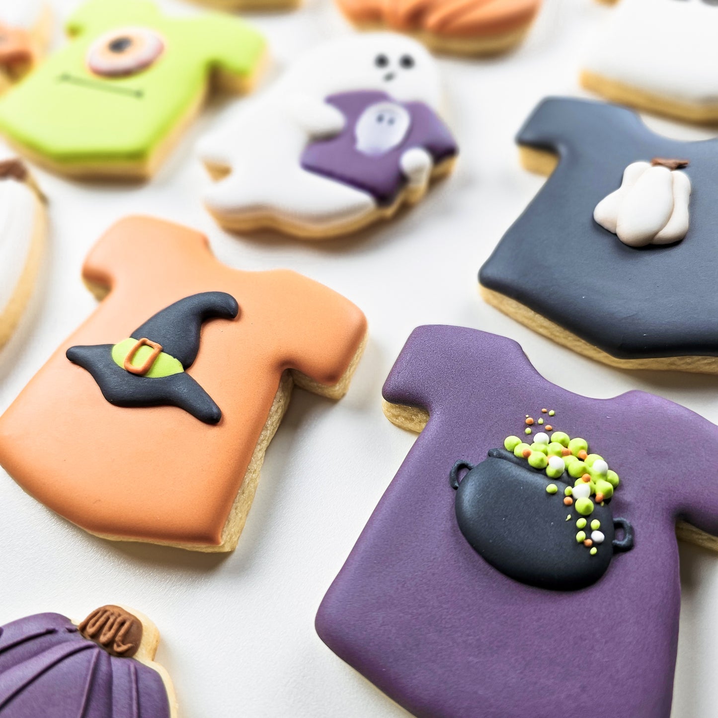Halloween-themed cookies with decorative royal icing transfers on a white surface