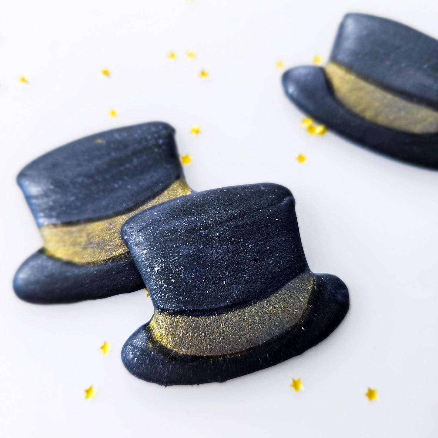Top hats royal icing transfers with gold bands on a white background