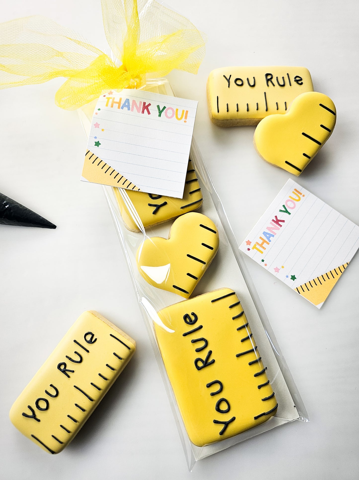 Yellow sugar cookies with 'You Rule' text, packaged and displayed on a white surface.