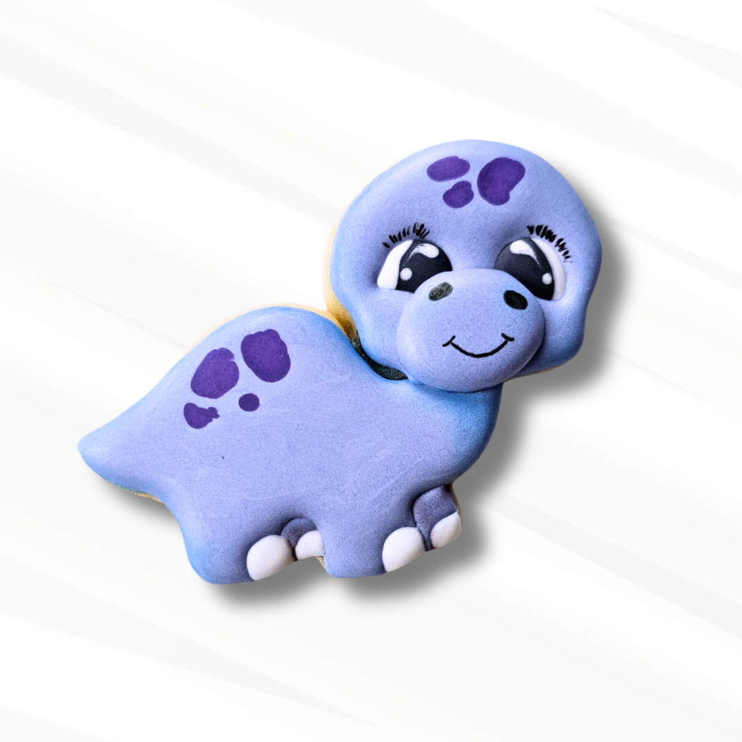 Purple dinosaur-shaped sugar cookie with a smiling face on a white background
