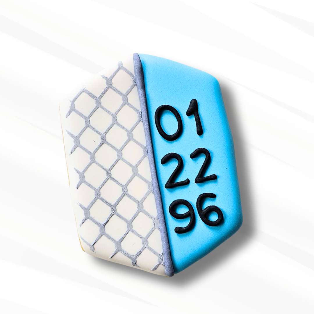 hexagon shaped decorated sugar cookie featuring a chain link pattern and a date on a white background